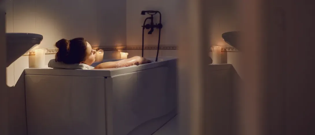 A woman relaxing in a candlelit bath