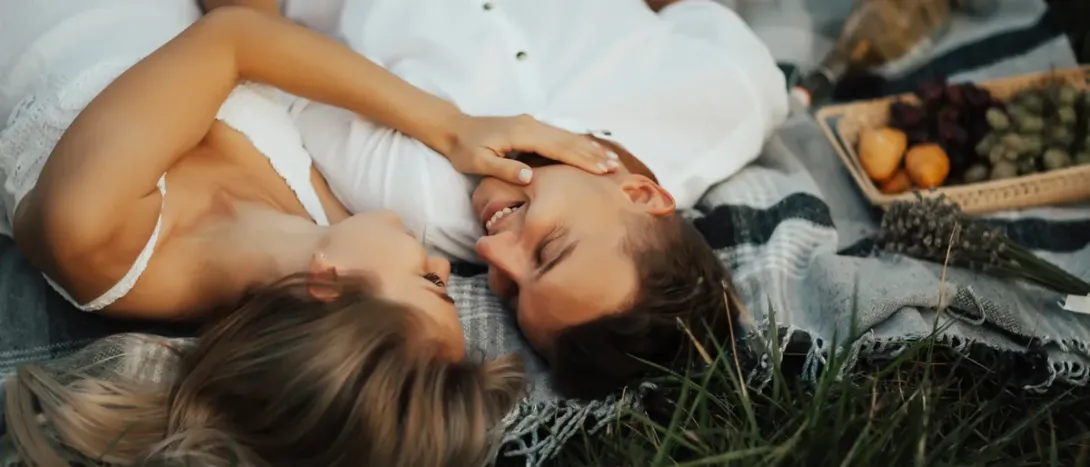 A couple lying on a picnic blanket