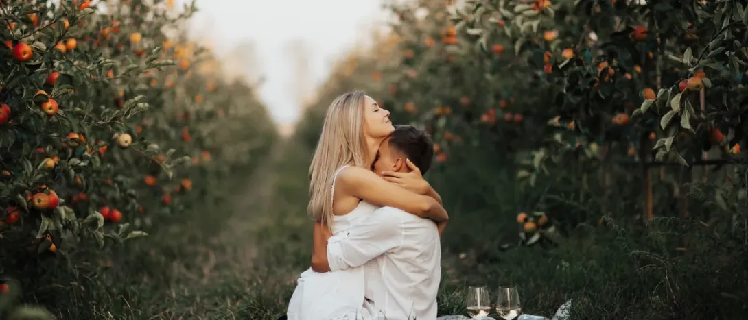A couple embracing in an orchard