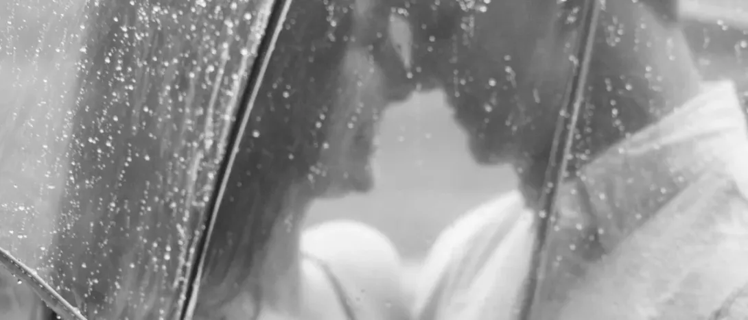 A couple seen through rain on a window