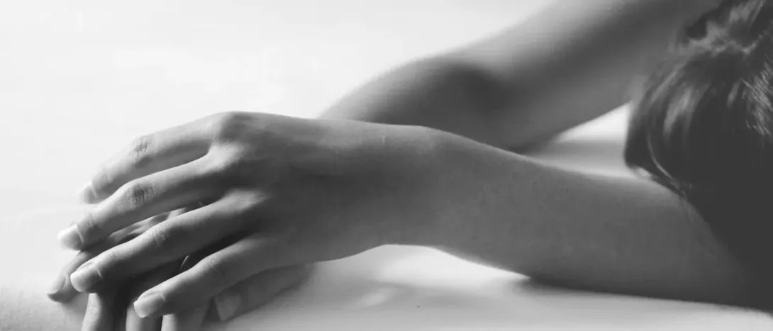 Two hands touching on a white sheet