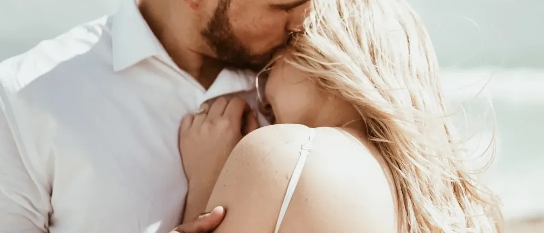A man kissing a woman's forehead